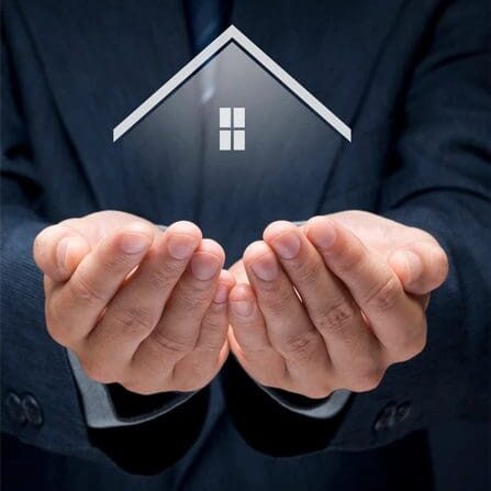 A person in a suit holds out hands with a floating icon of a house with a window above the palms, symbolizing protection or care of a home.